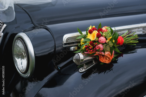 Wedding bouquet lies on a retro car