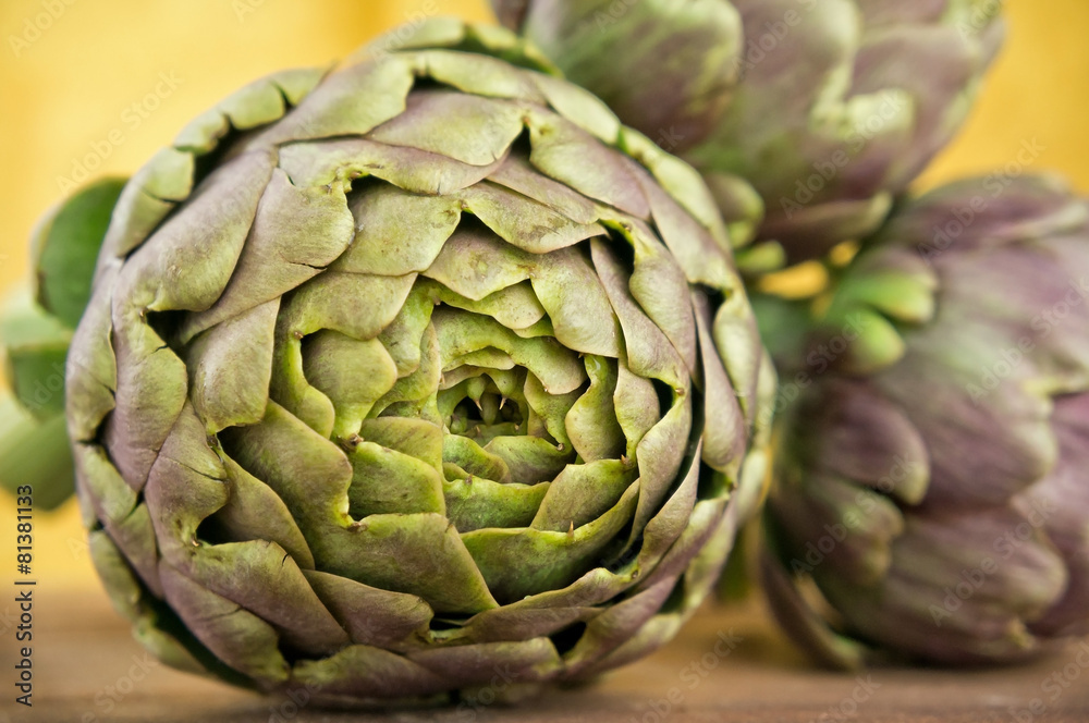 Obraz premium Group of fresh artichokes on wooden table