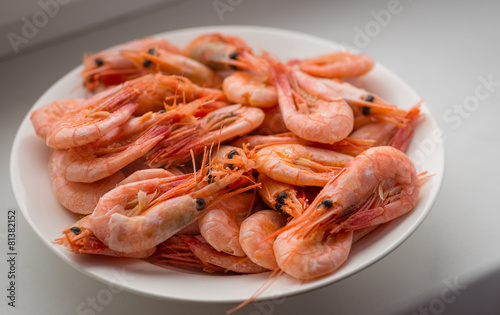 Cooked shrimps on white plate. Shallow depth of field.