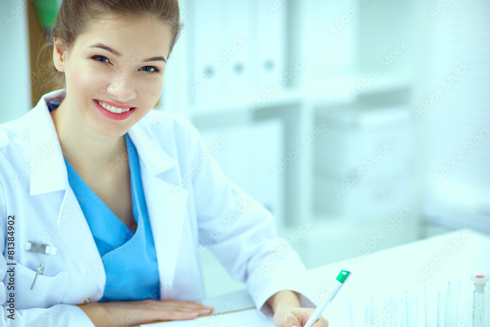 Woman researcher is surrounded by medical vials and flasks Woman researcher is surrounded by medical vials and flasks