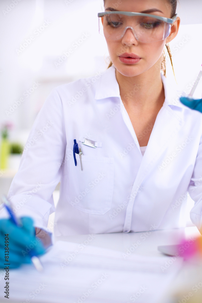 Woman researcher is surrounded by medical vials and flasks Woman researcher is surrounded by medical vials and flasks