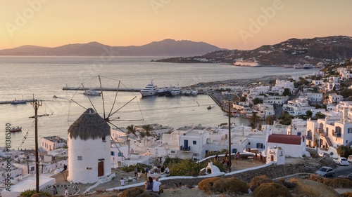 view of Mykonos, windmill and port with cruise ship at sunset