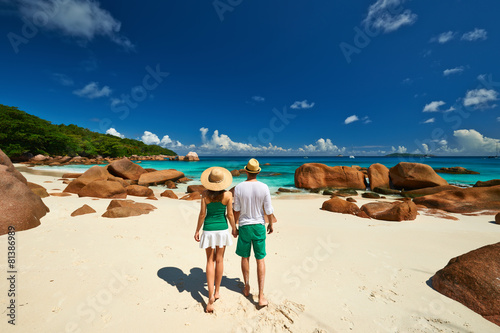 Couple in green walking on a beach at Seychelles