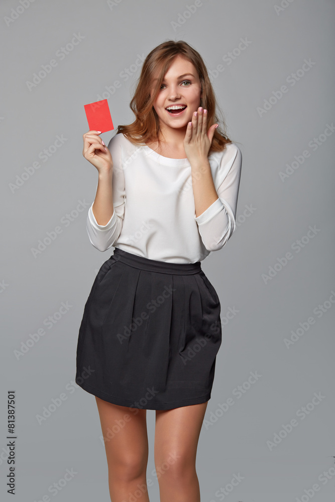 Naklejka premium Surprised business woman showing blank credit card, over gray ba