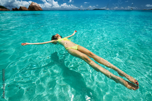 Woman in yellow bikini lying on water