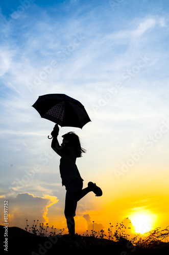Motion blur jumping Umbrella girl with sunset silhouette © nuiiko