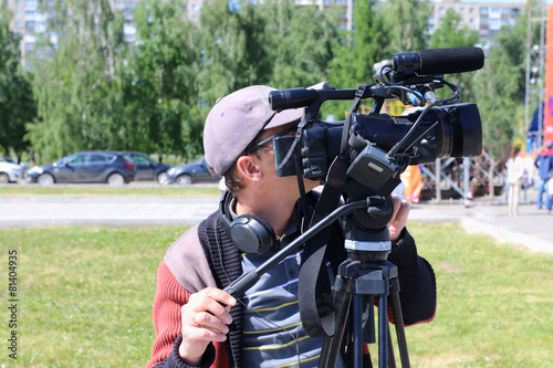 Videographer with big modern camera work at event outdoor at sum