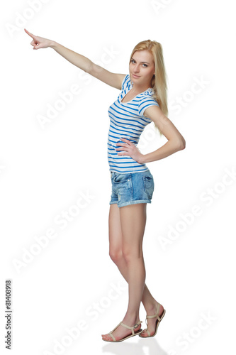 Happy young denim girl in shorts standing casually in full lengt