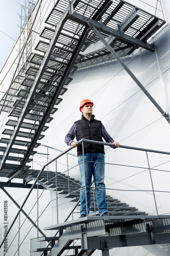 construction worker standing on steel staircase at factory