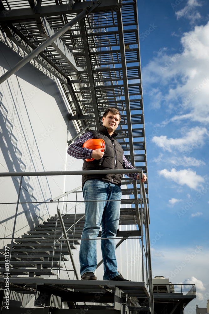 architect standing on metal staircase on side of the factory architect standing on metal staircase on side of the factory