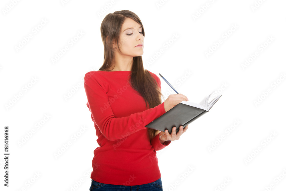 Female student writing in notebook. Female student writing in notebook.