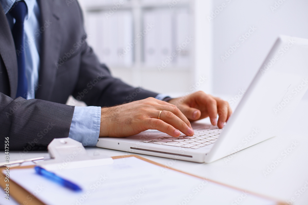 Businessman sitting in office, working with laptop computer Businessman sitting in office, working with laptop computer