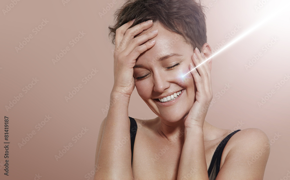 Fototapeta premium happy smiling woman with ray of laser on her ideal skin