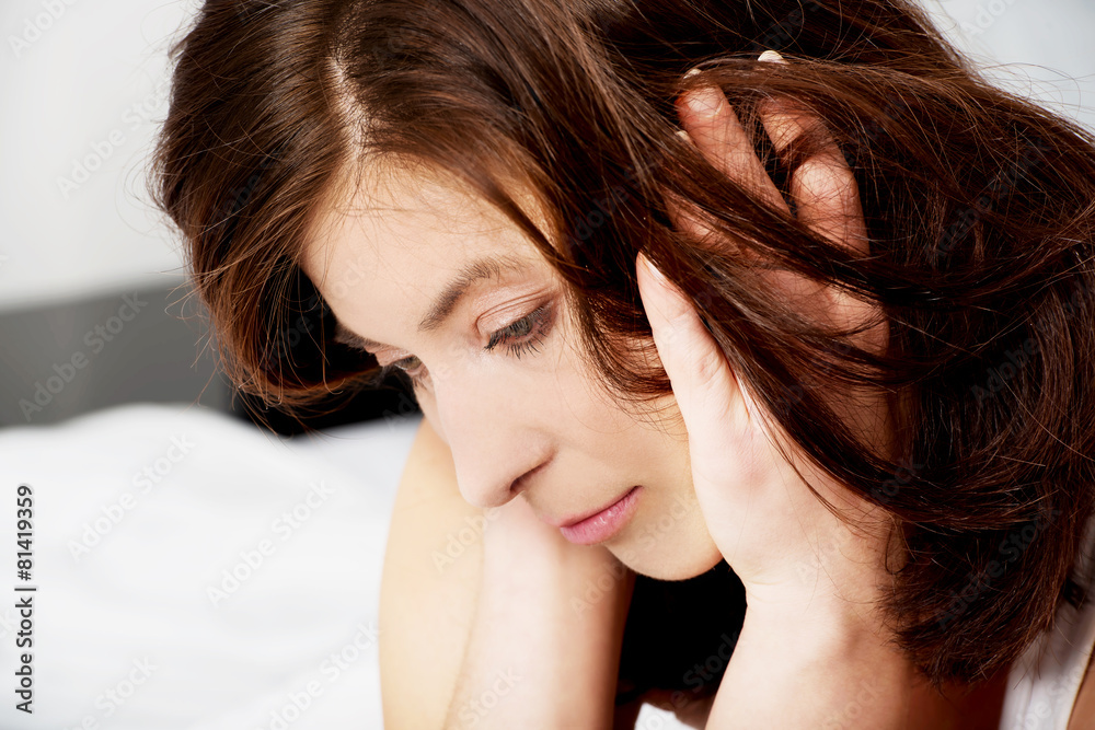Obraz premium Sad depressed woman on bed.