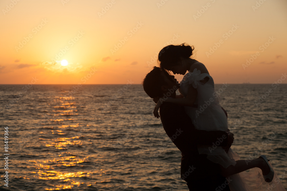 Silhouettes of man lifting girl.