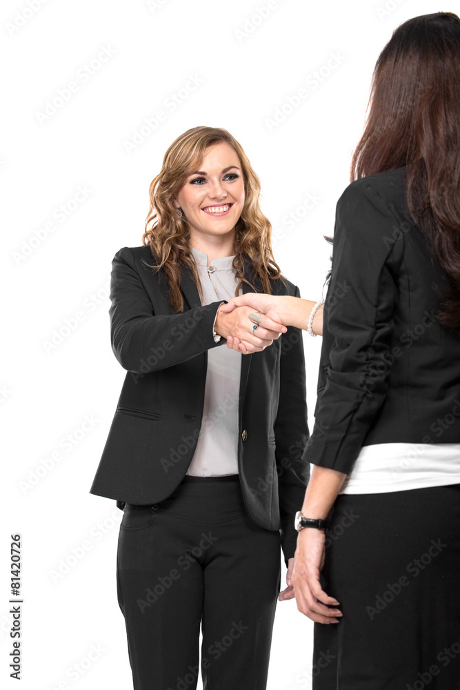 Two young businesswoman making a deal and shaking hands isolated Two young businesswoman making a deal and shaking hands isolated