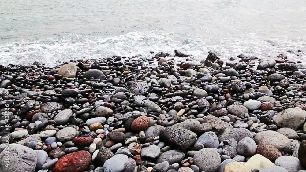 Stones with waves on beach of shore or coast of ocean or sea Stones with waves on beach of shore or coast of ocean or sea
