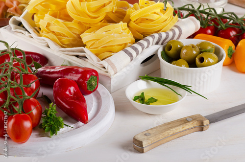 Italian food ingredients with pasta and fresh vegetables.