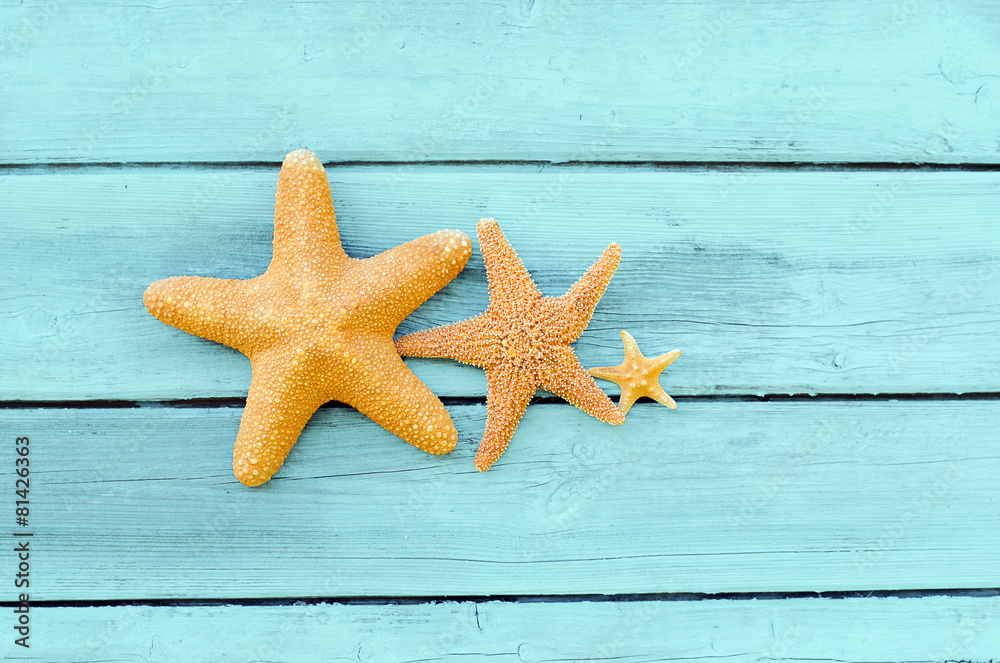 Three starfish on a blue wooden background Three starfish on a blue wooden background