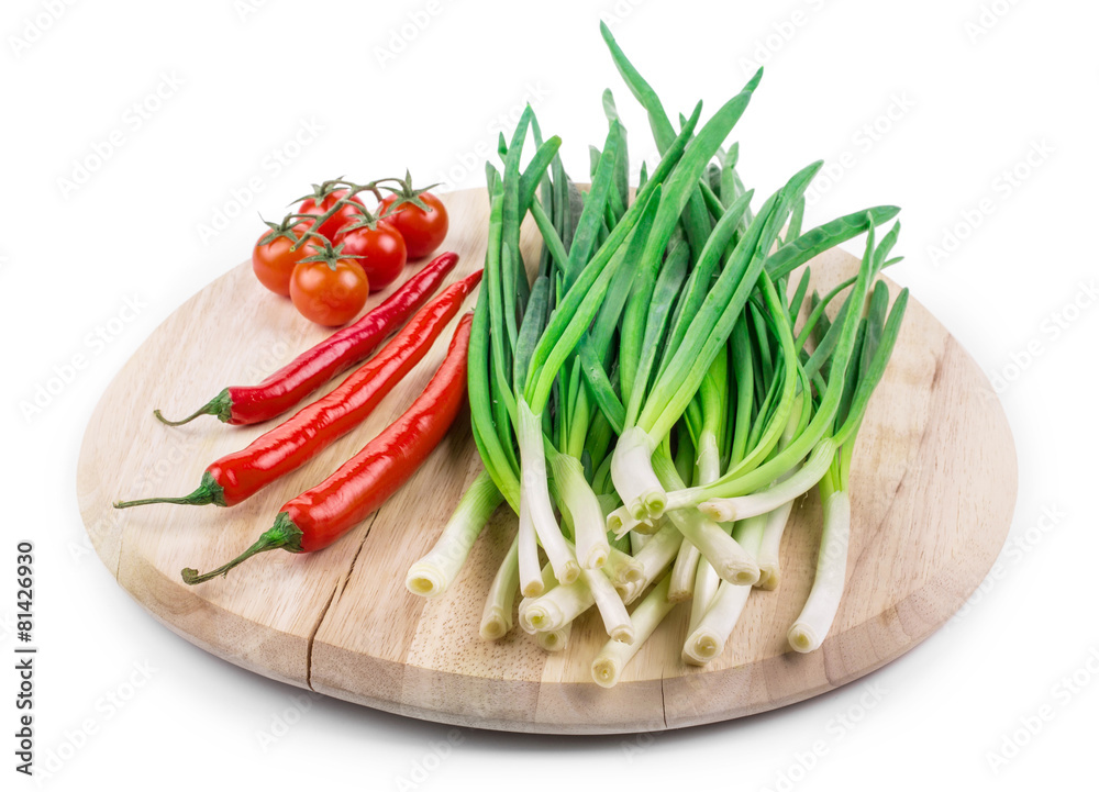 Bunch of green onion on wooden platter.
