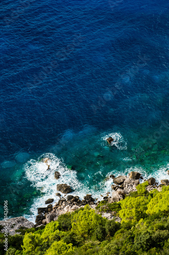 Aerial view of seashore with blue sea and green vegetation