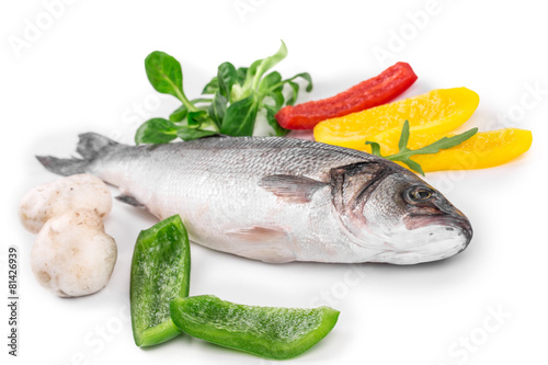 Fresh seabass with lemon and tomato on plate.