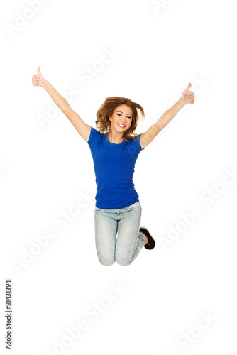Young happy woman jumping with thumbs up.