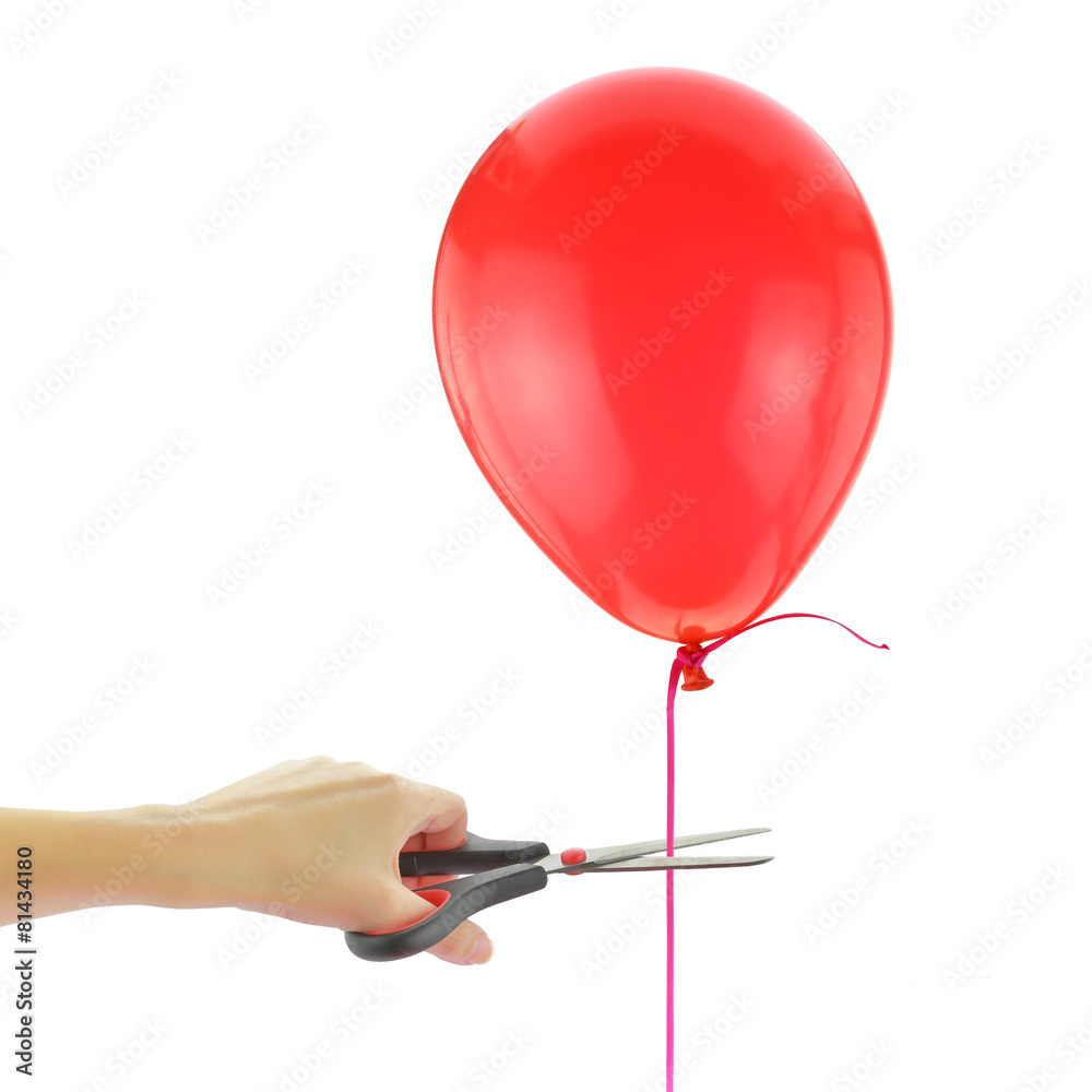 Scissors about to cut loose a balloon isolated on white Stock