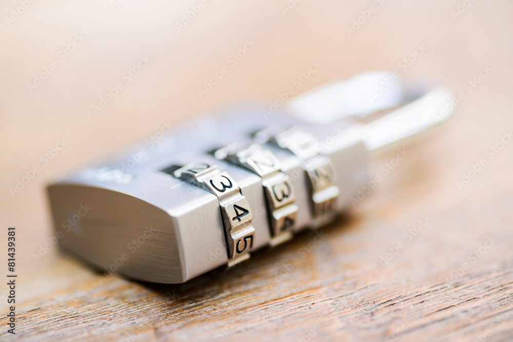 Combination padlock close up with chrome numbers on wooden backg Combination padlock close up with chrome numbers on wooden backg