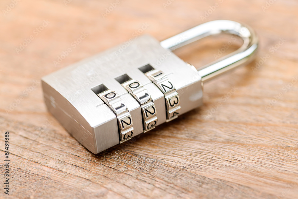 Combination padlock close up with chrome numbers on wooden backg Combination padlock close up with chrome numbers on wooden backg