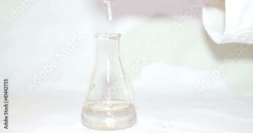 Close up shot of a hand putting some chemicals into an erlenmeyers flask to check the hardness of the water-the water is hard photo