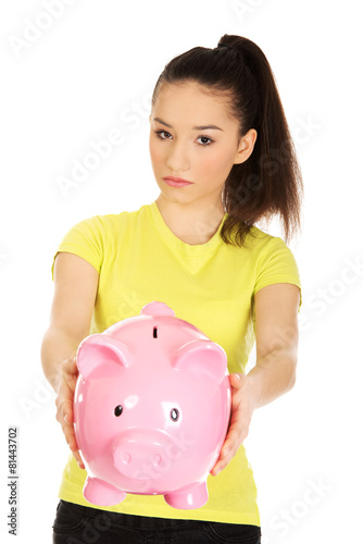 Unhappy woman holding piggybank.