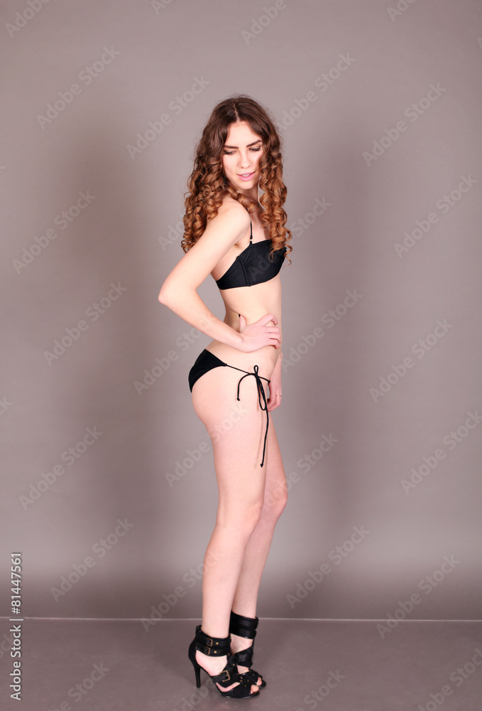 Young sexy bikini model. Woman in swimsuit posing in studio. 