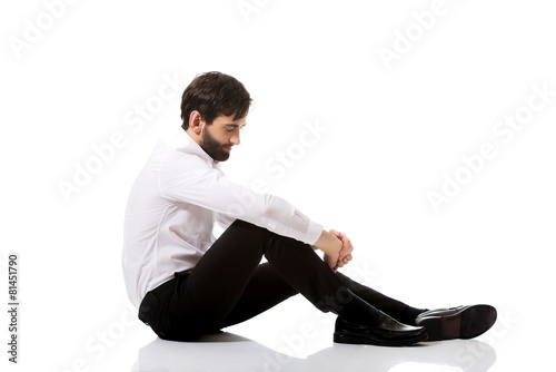 Young businessman sitting on the floor.