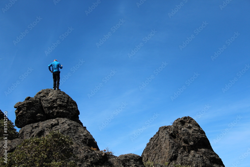 Mann steht auf einem Berg