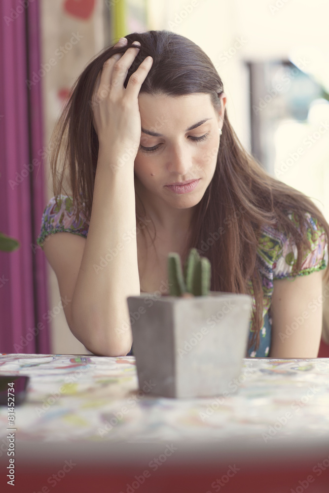 Young latin woman at street bar worried