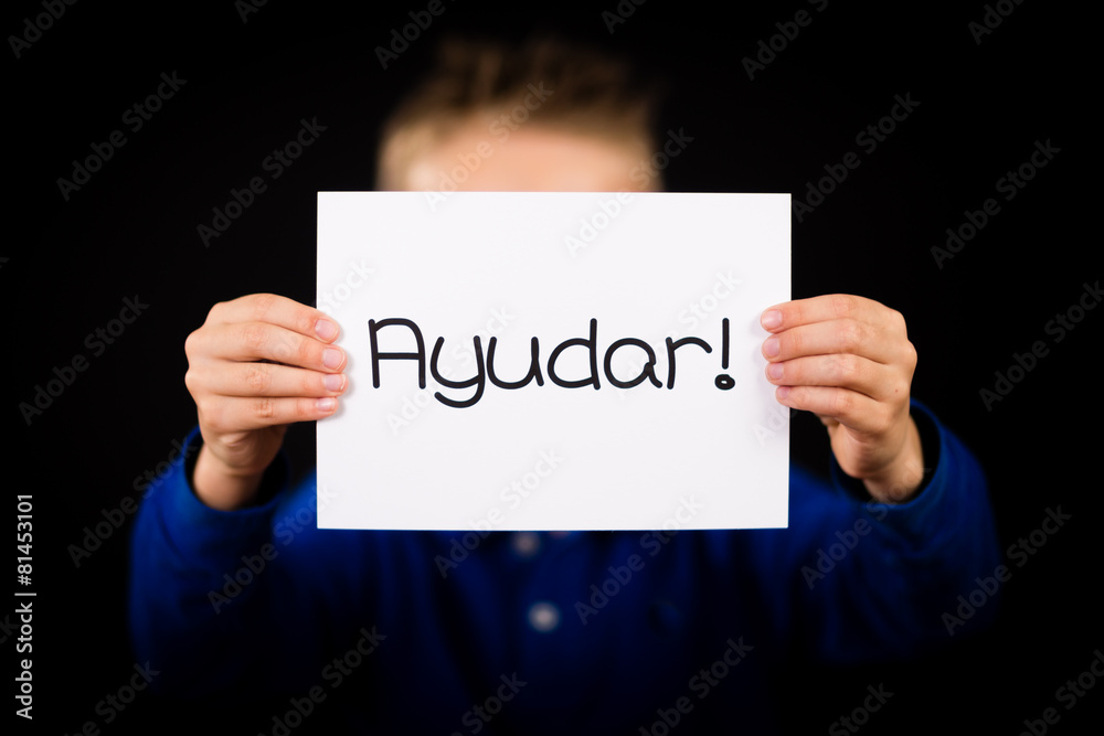Child holding sign with Spanish word Ayudar - Help Child holding sign with Spanish word Ayudar - Help