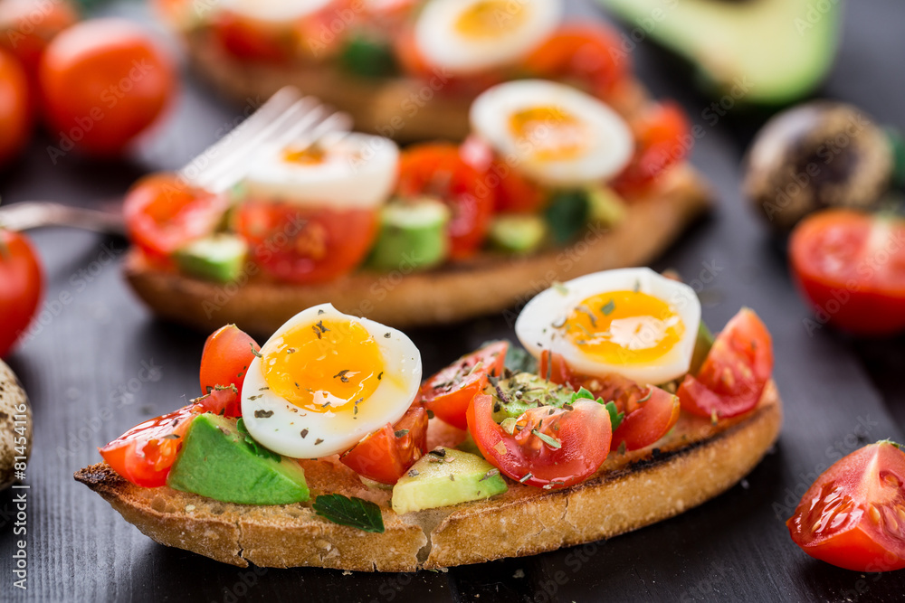 Bruschetta with tomato, avocado and quail egg Bruschetta with tomato, avocado and quail egg
