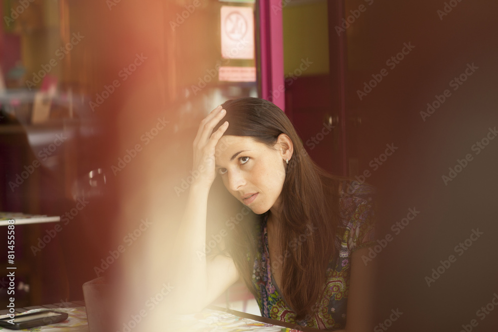 Fototapeta premium Young latin woman at street bar worried