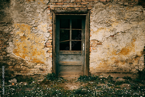 Old door on abandoned building facade