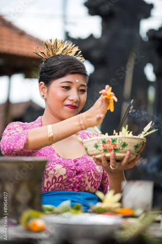Balinese woman in temple with offering for Gods