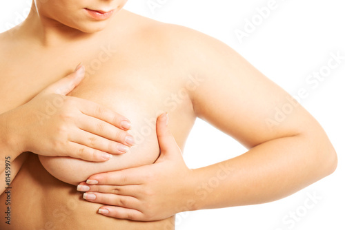 Overweight woman examining her breast