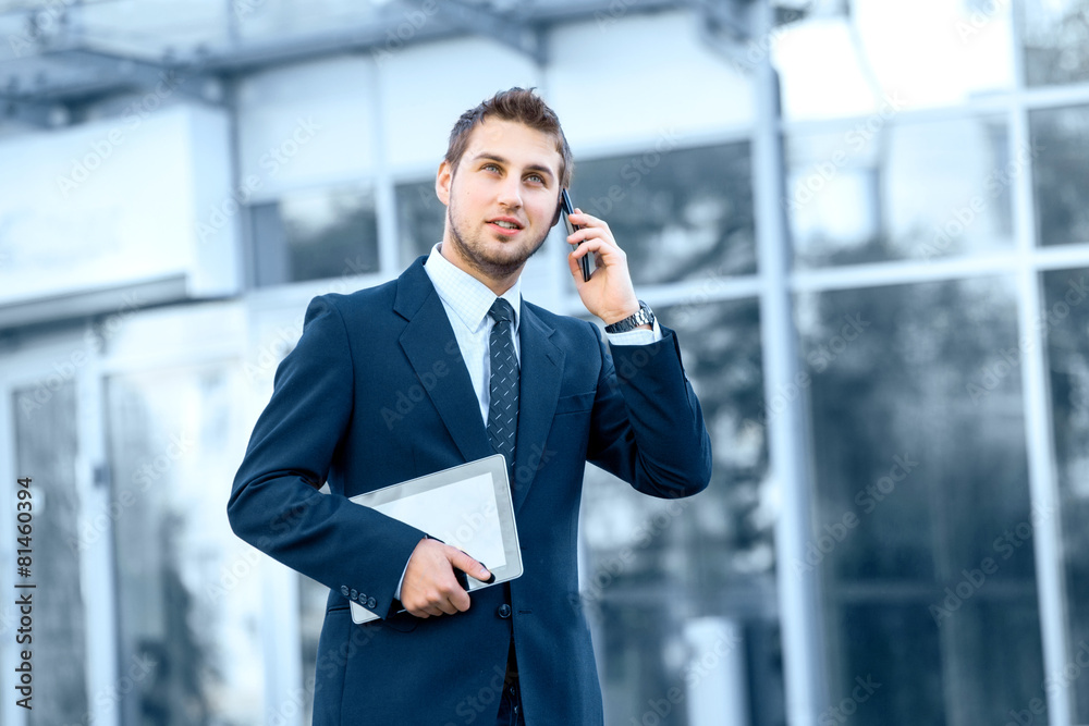 Attractive young businessman using a cell phone, Attractive young businessman using a cell phone,