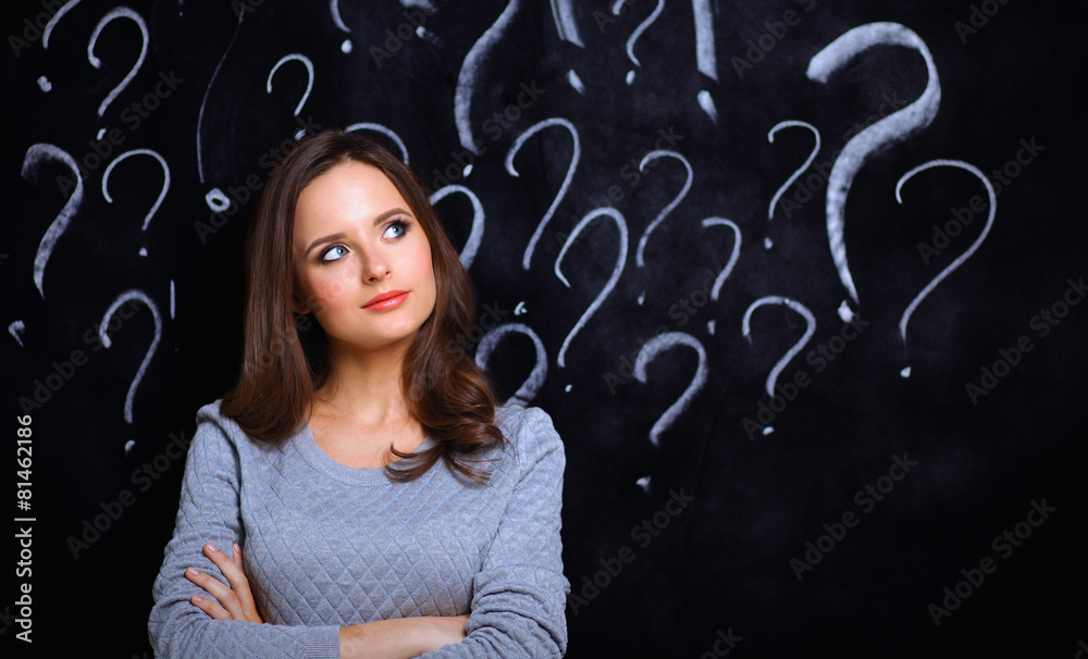 Young girl with question mark on a gray background Young girl with question mark on a gray background