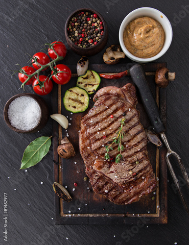 Fotografie Beef rump steak on black stone table