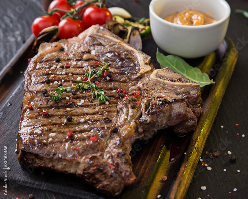 Beef t-bone steak on black stone table photo