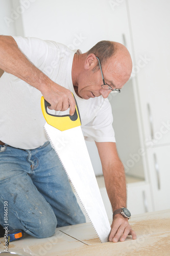 Carpenter using a hand saw
