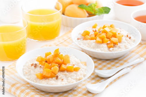 plates of oatmeal with fresh apricots, orange juice and tea