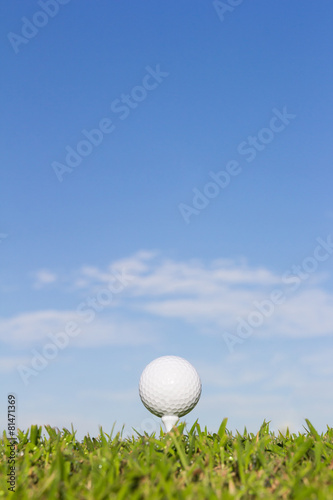 Golf ball on tee with sky background