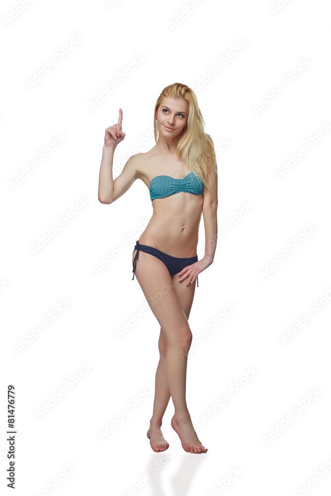 Full length beautiful slim tanned woman in bikini pointing up at Full length beautiful slim tanned woman in bikini pointing up at